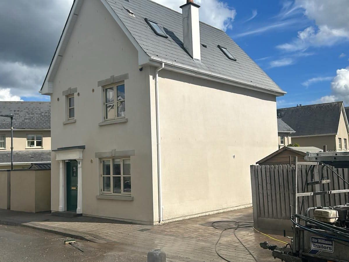 Rendered house wall streaked with algae staining, and the same wall cleaned