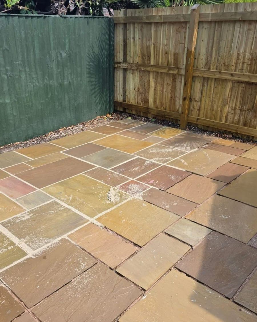 Paved patio part way through cleaning, showing the cleaned and soiled surface